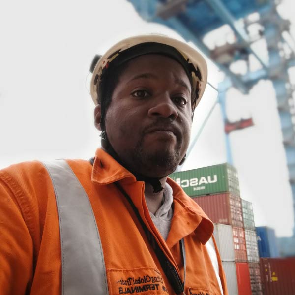 Portrait of Bill Sanders, dockworker in safety gear at a shipping terminal. - Supply Chain Transparency