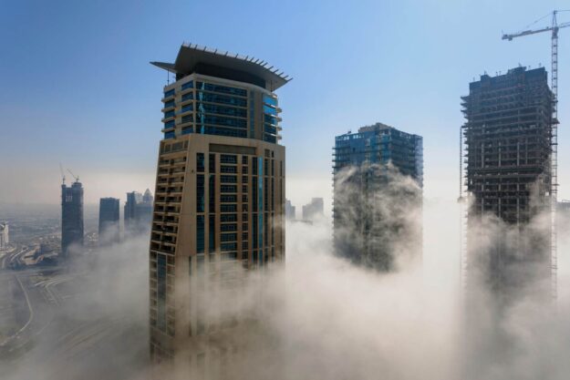 Dubai skyscrapers pierce a low-lying cloud layer. - Supply Chain Transparency