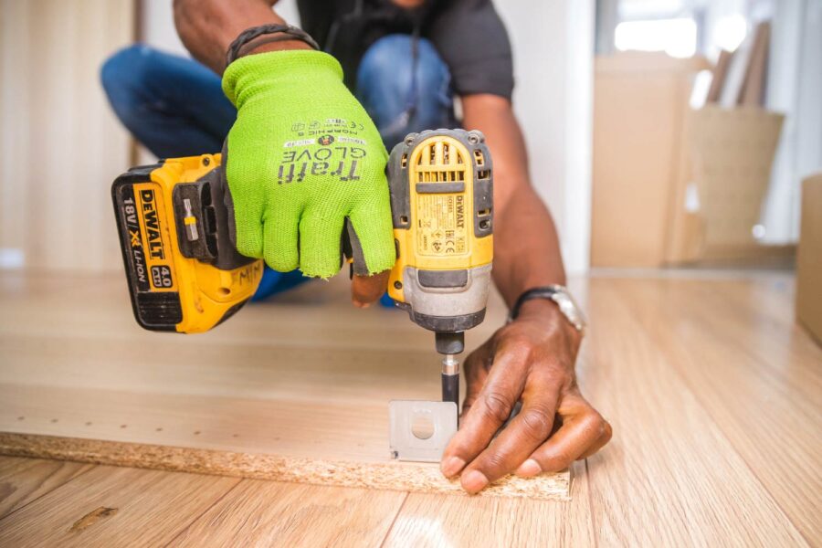 Close-up of hands using a DeWalt drill during a home improvement project. - Supply Chain Transparency