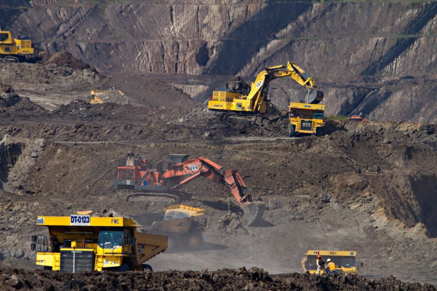 Heavy machinery at an open-pit mine. Large excavators and haul trucks move earth and ore. - Supply Chain Transparency