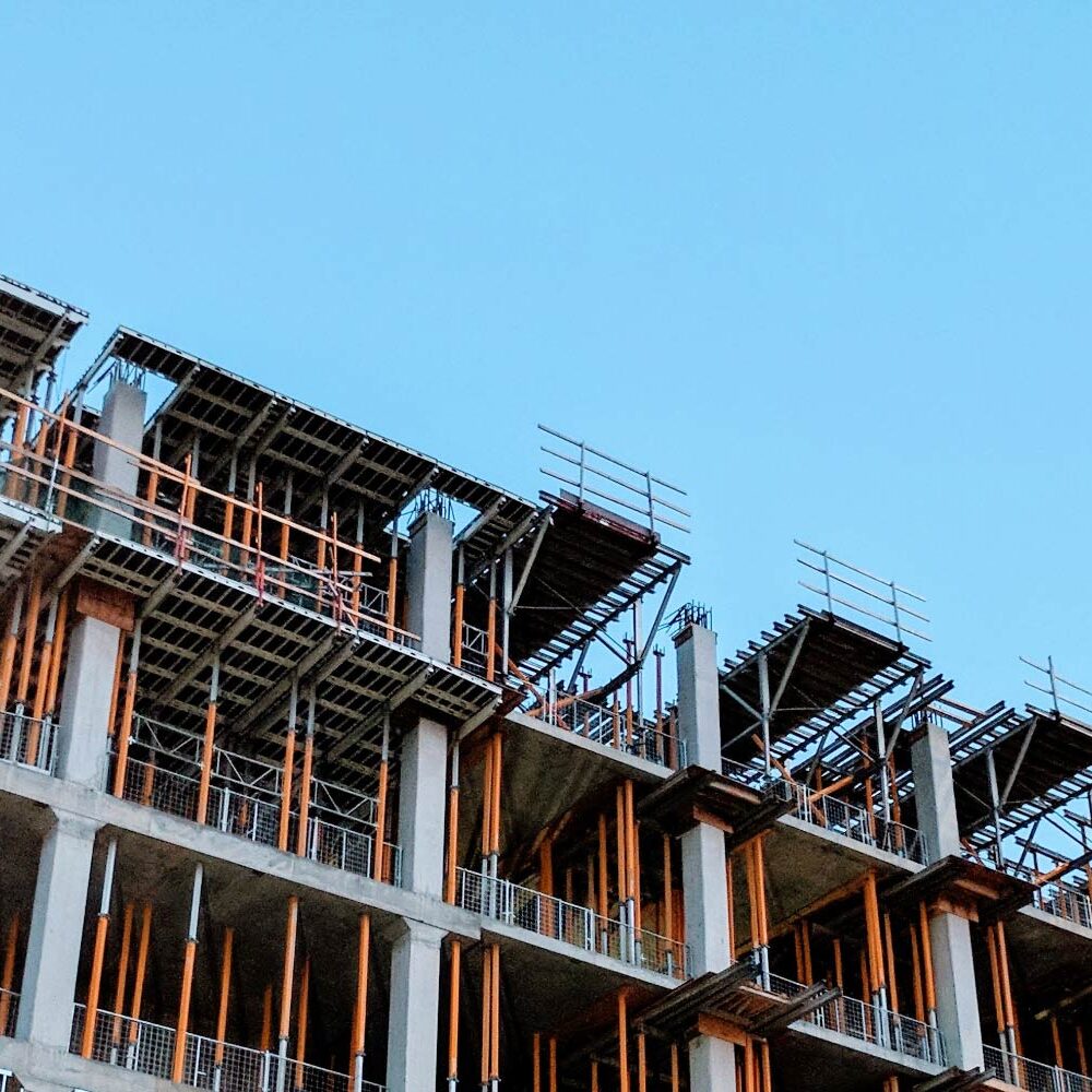 High-rise building under construction, showing concrete framework and scaffolding. - Supply Chain Transparency