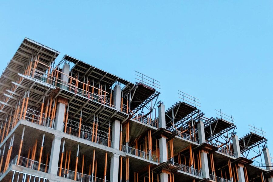 High-rise building under construction, showing concrete framework and scaffolding. - Supply Chain Transparency