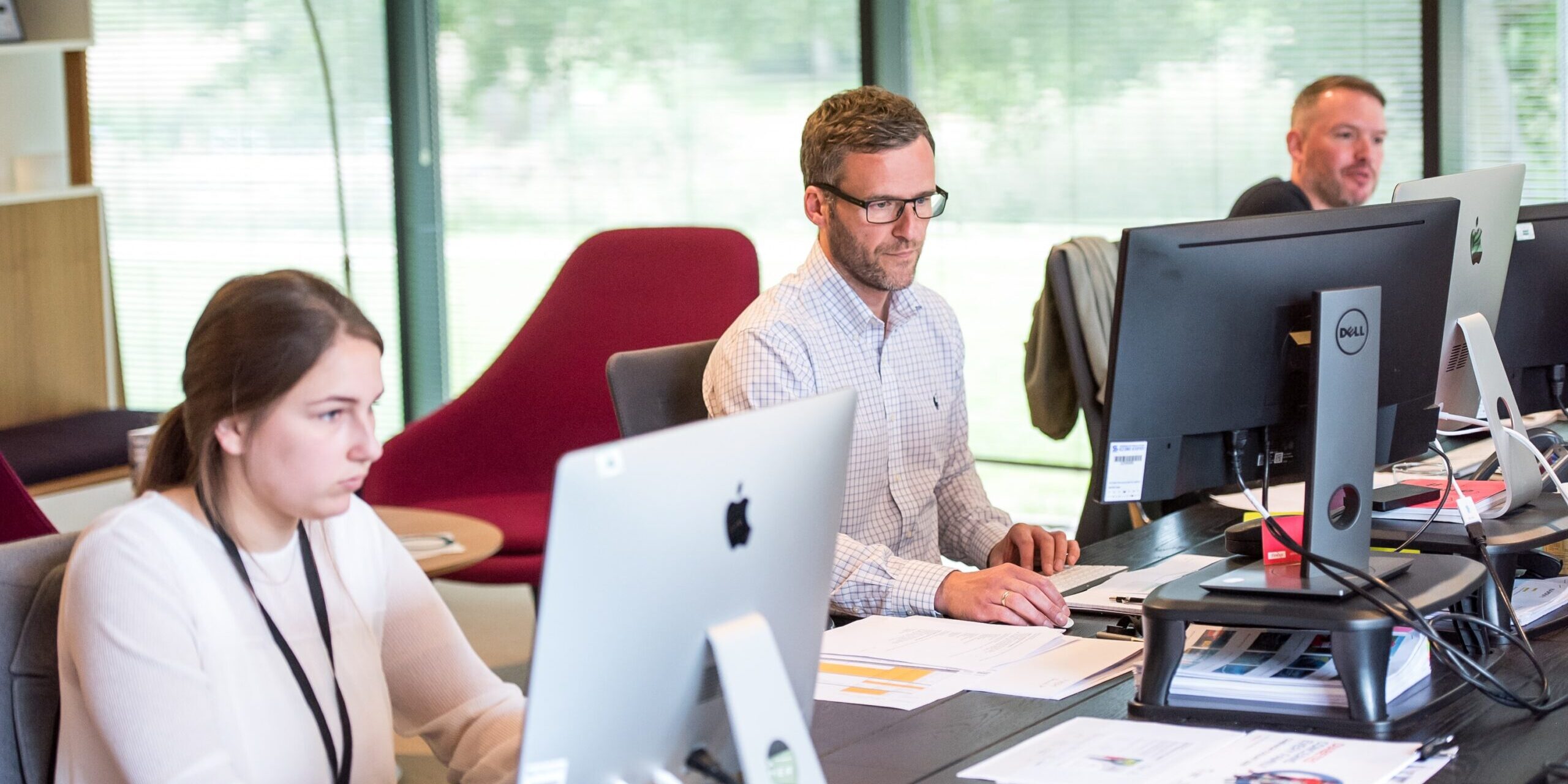 Educating Employees Training and Awareness Programs to Combat Fraud Three colleagues work on computers, focusing on fraud prevention training. - Supply Chain Transparency