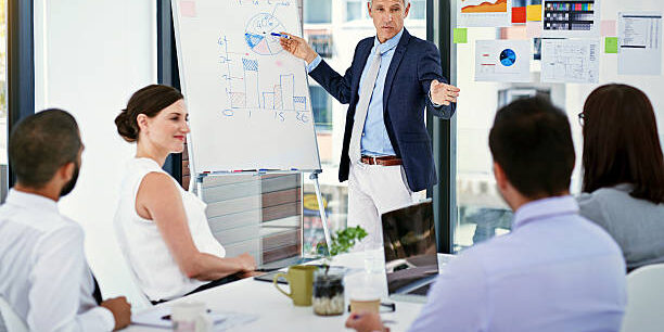 Fraud Risk Assessment Evaluating Vulnerabilities in Supply Chains Business team listening to a presenter giving a presentation on fraud risk assessment and supply chain vulnerabilities. - Supply Chain Transparency