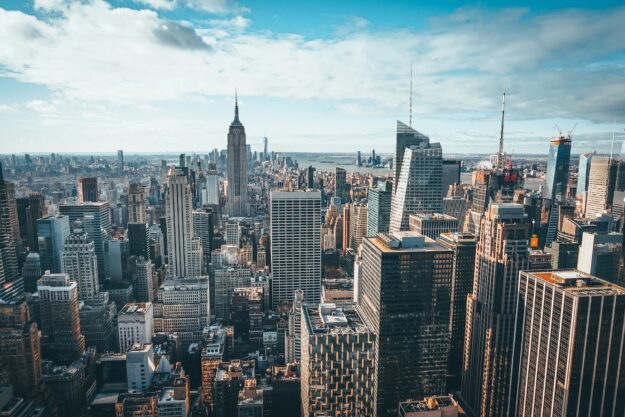 Supply Chain Reshoring: Benefits, Challenges, and Opportunities Aerial view of the New York City skyline, showcasing numerous skyscrapers. - Supply Chain Transparency