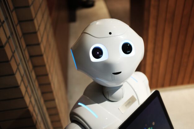 A future robot is holding a laptop and looking at the camera while utilizing emerging technologies for supply chain management. A future robot is holding a laptop and looking at the camera while utilizing emerging technologies for supply chain management.