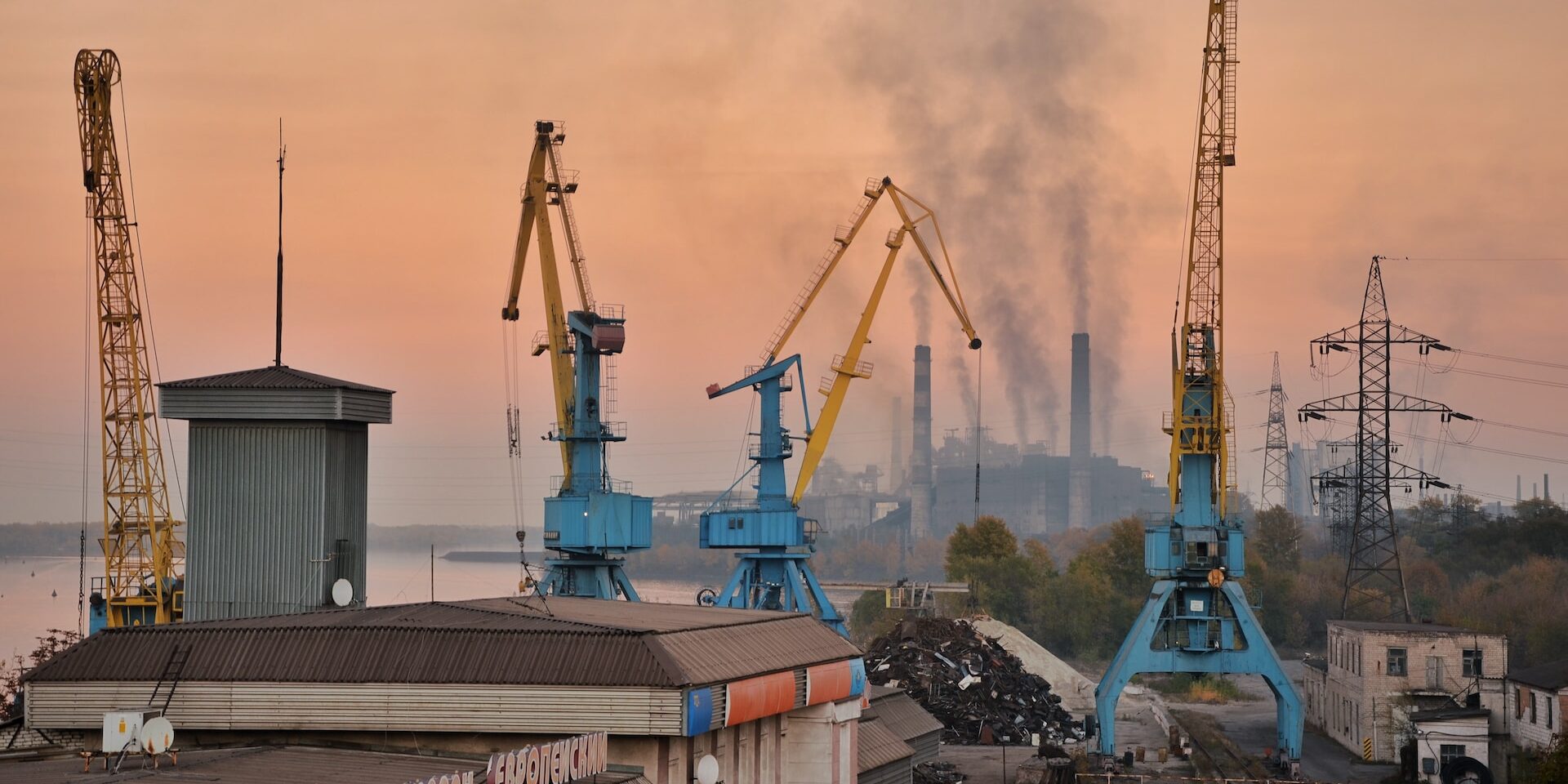 Industrial port cranes at sunset, showcasing reverse logistics and sustainable supply chain management. - Supply Chain Transparency