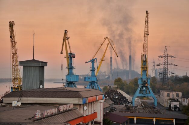 The Role of Reverse Logistics in Sustainable Supply Chain Management Industrial port cranes at sunset, showcasing reverse logistics and sustainable supply chain management. - Supply Chain Transparency