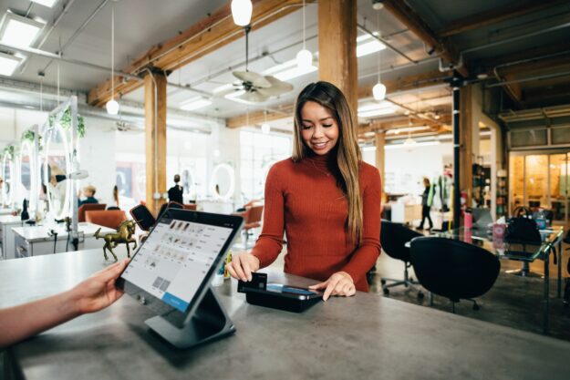 The Rise of Omni-Channel Supply Chains in Retail Woman using contactless payment at a retail checkout. Omni-channel retail. - Supply Chain Transparency