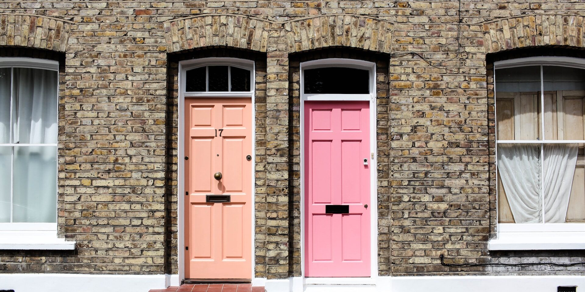 Trade Liberalization: Opening Doors to Global Markets Two pastel-colored doors on a brick building. One door is peach, the other pink. Number 17 is visible. - Supply Chain Transparency
