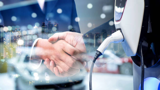 The Power of Collaboration in Supply Chain Innovation Business handshake with electric vehicle charging station; collaboration in supply chain innovation. - Supply Chain Transparency