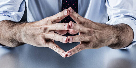 The Human Element: Addressing Employee-Related Fraud in Supply Chains Close-up of hands clasped together, suggesting contemplation or decision-making. Relates to employee fraud in supply chains. - Supply Chain Transparency