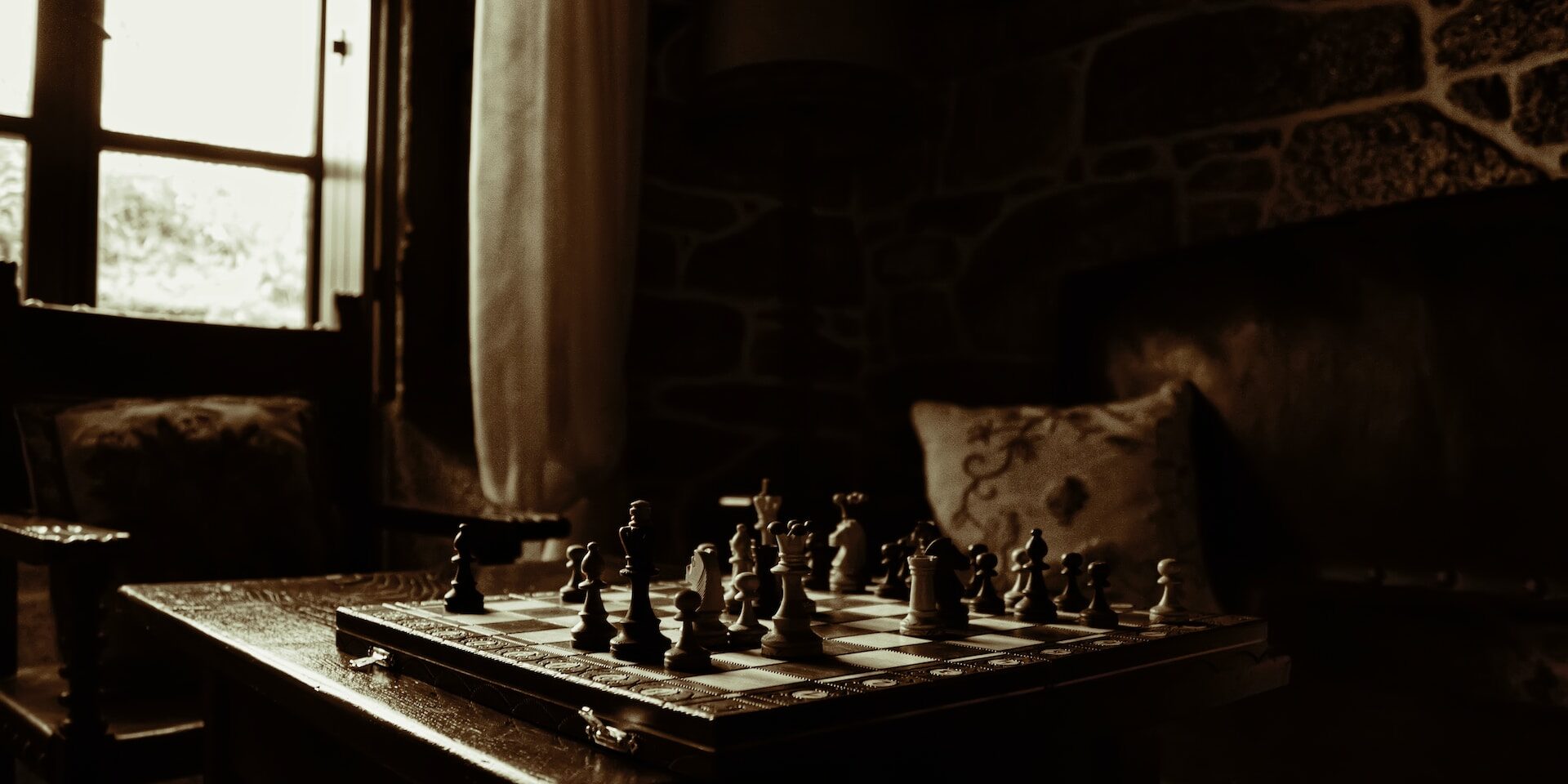 Chessboard set on a dark wooden table in a dimly lit room, representing the complex, opaque nature of a supply chain lacking transparency. - Supply Chain Transparency