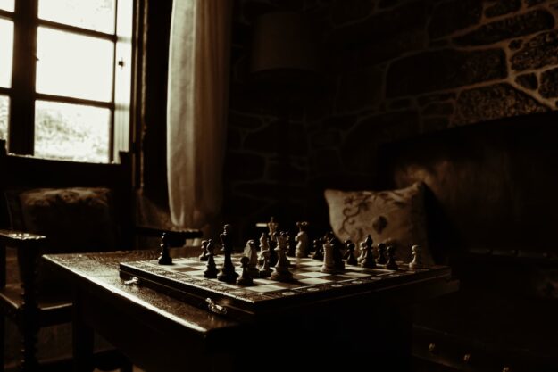 javier-grixo-p1opmw12wvk-unsplash Chessboard set on a dark wooden table in a dimly lit room, representing the complex, opaque nature of a supply chain lacking transparency. - Supply Chain Transparency