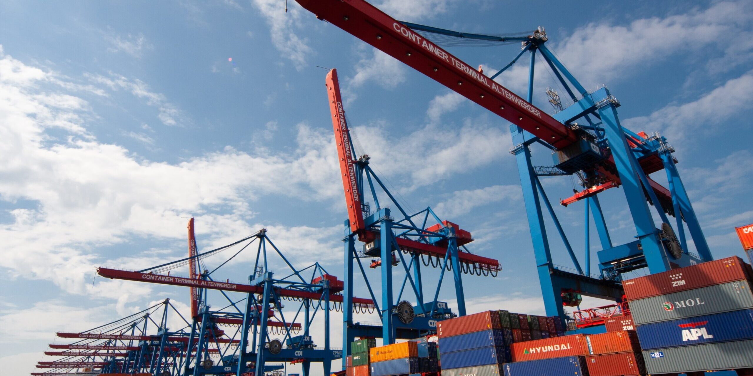 Container ship at port with large cranes; international trade and economic development. - Supply Chain Transparency