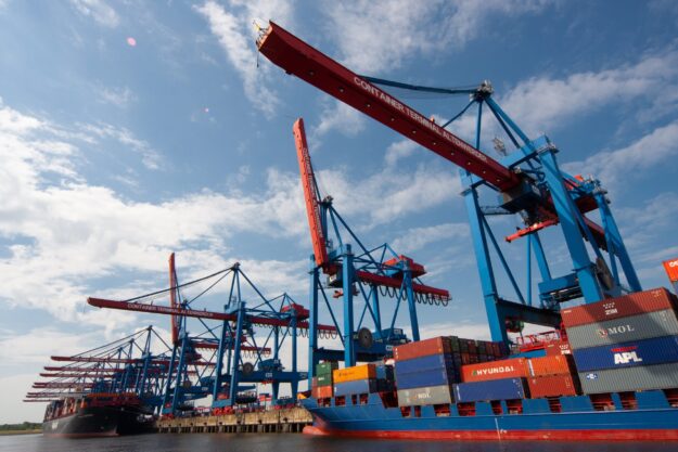 The Role of International Trade in Economic Development Container ship at port with large cranes; international trade and economic development. - Supply Chain Transparency
