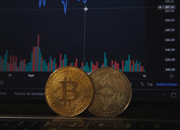 The Rise of Blockchain in Supply Chain Management Bitcoin and Ethereum cryptocurrency coins on a laptop displaying a blockchain price chart. Illustrating blockchain's use in supply chain management. - Supply Chain Transparency