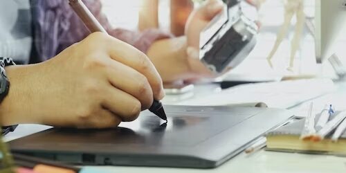 Person using a stylus on a graphics tablet, illustrating supply chain digitization. - Supply Chain Transparency