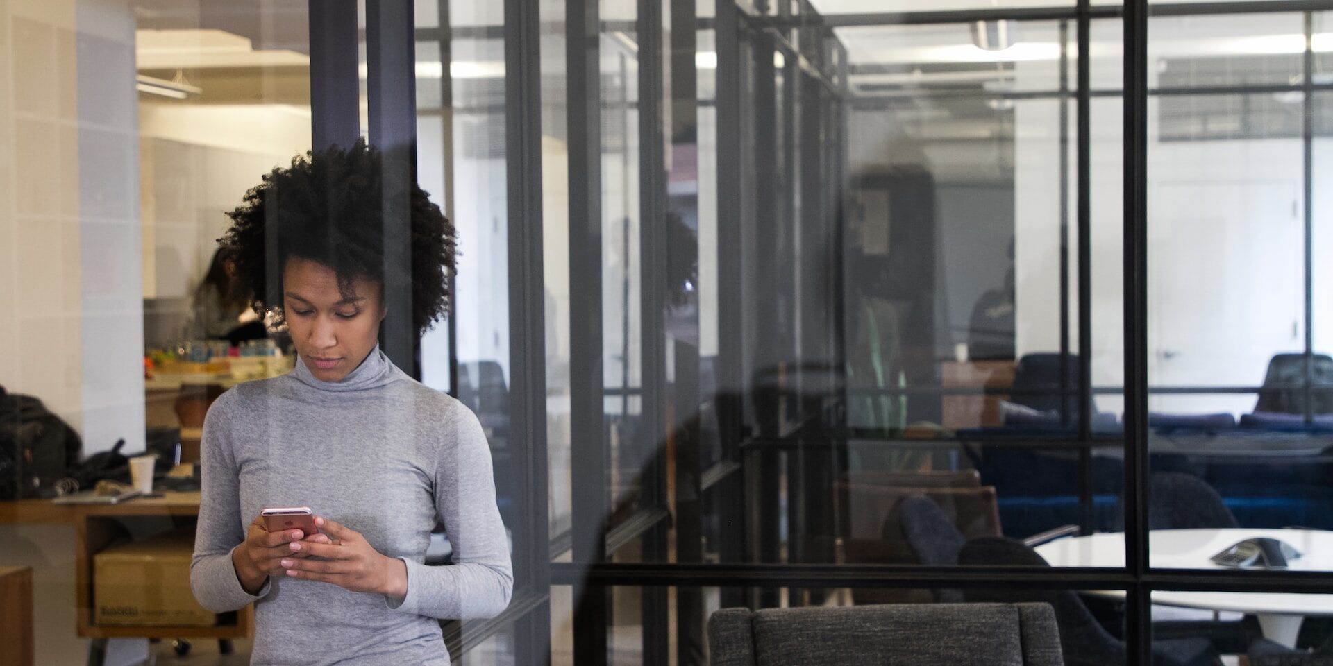 Woman using smartphone in modern office. Preventing internal fraud. - Supply Chain Transparency