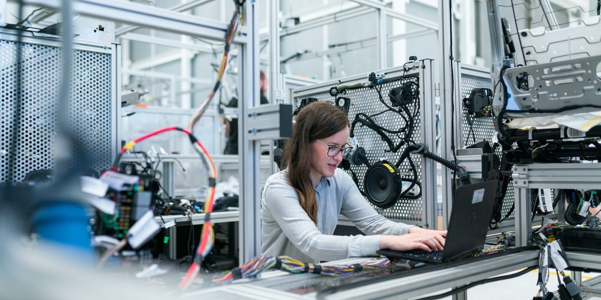 The Role of Artificial Intelligence in Supply Chain Optimization Female engineer using laptop in a modern factory setting, showcasing AI's role in supply chain optimization. - Supply Chain Transparency