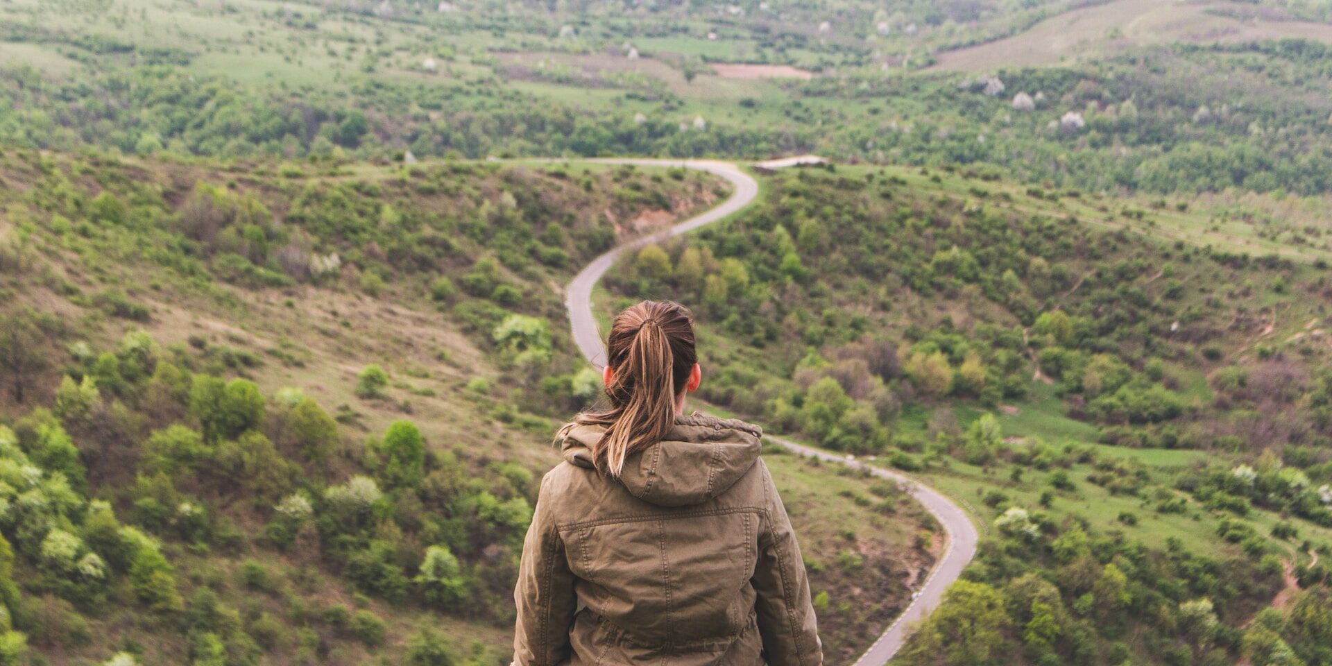 From Supplier to Shelf: Mapping the Journey towards Transparent Supply Chains Woman sits on a cliff overlooking a winding road, contemplating the journey ahead. Transparent supply chain concept. - Supply Chain Transparency