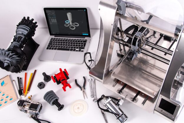 The Role of Automation and Robotics in Modern Supply Chains 3D printer, laptop, and 3D printed parts; illustrating automation in modern supply chains. - Supply Chain Transparency