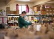 Volunteer packing groceries into paper bags at a food bank, reducing waste in the supply chain. - Supply Chain Transparency