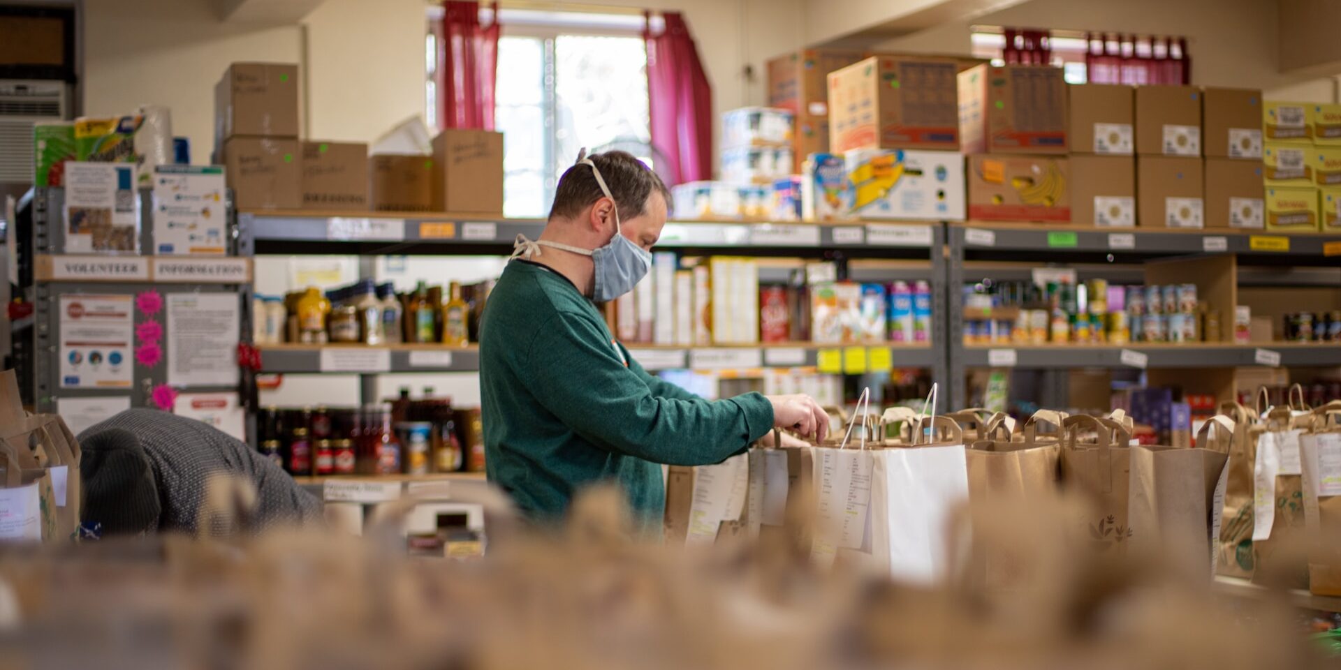 Reducing Waste in Supply Chains: Approaches and Benefits Volunteer packing groceries into paper bags at a food bank, reducing waste in the supply chain. - Supply Chain Transparency