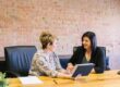 Two businesswomen collaborate on a tablet, showcasing effective talent management in supply chain. - Supply Chain Transparency