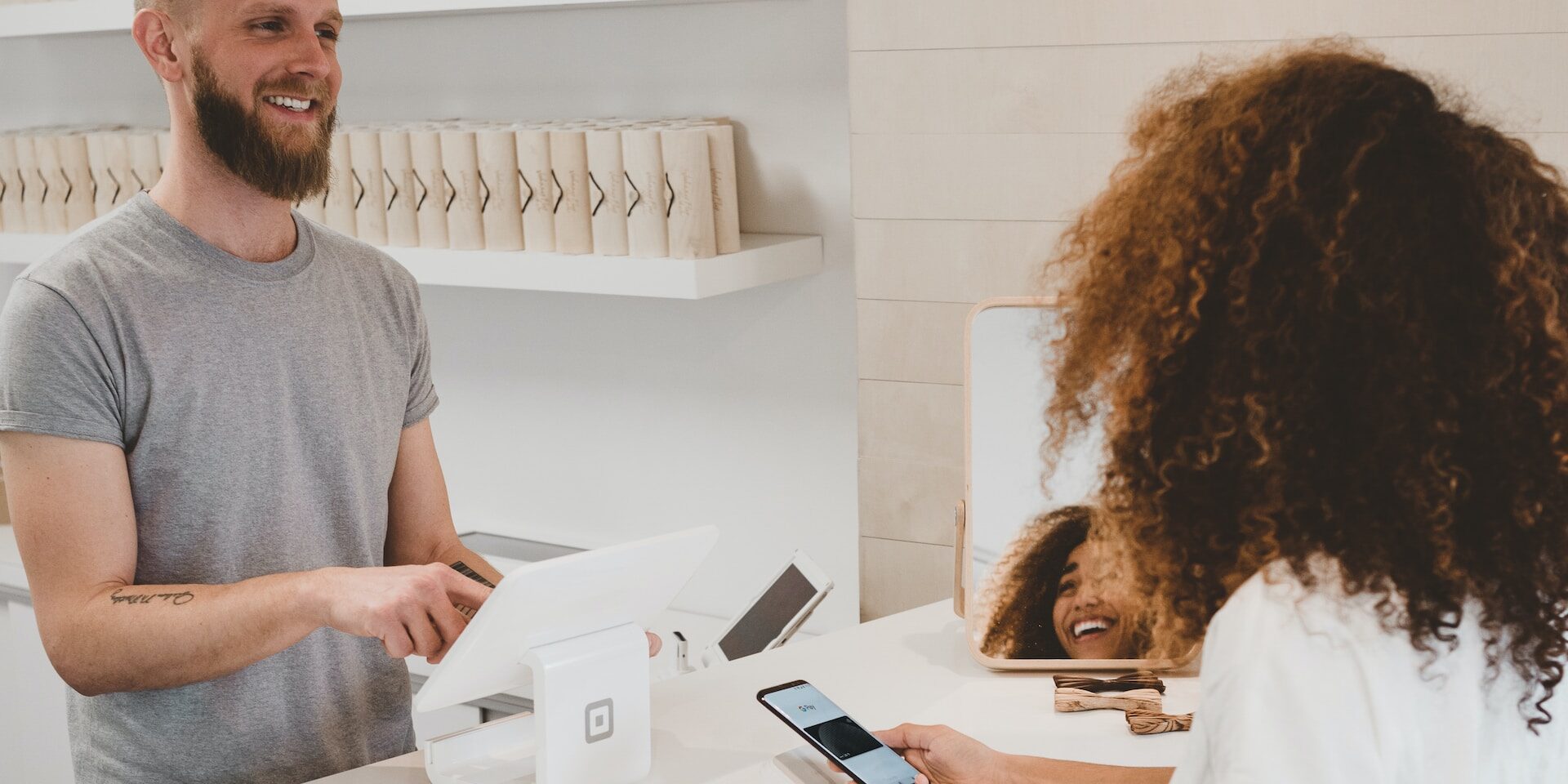 The Connection Between Supply Chain and Customer Satisfaction Smiling shopkeeper processing contactless payment from customer. Excellent customer service and supply chain connection. - Supply Chain Transparency