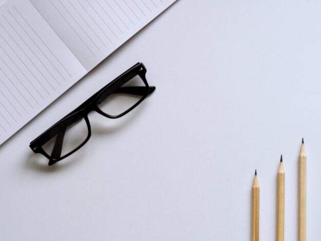 Understanding the Role of Ethics in Supply Chains Notepad, eyeglasses, and pencils on a white desk. Ethical supply chain concept. - Supply Chain Transparency