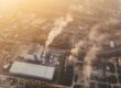 Aerial view of industrial plant emitting smoke, illustrating climate change's impact on global supply chains. - Supply Chain Transparency